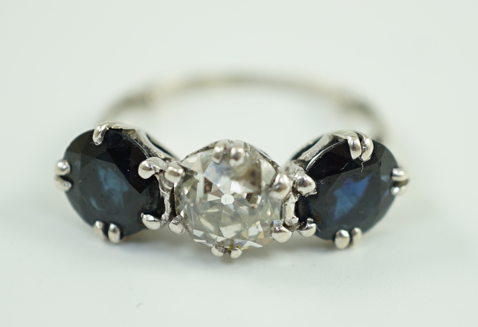 A white gold, sapphire and diamond set three stone ring, central stone approximately 1.4ct